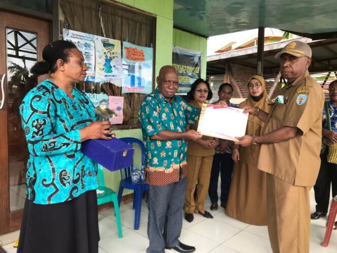 
 Kepala Dinas Perpustakaan dan Kearsupan, Yan Piet Bandi serahkan piagam dan platak penghargaan Nasional kepada Pemerintah Kampung dan Pengelola Perpustakaan Argosigemerai