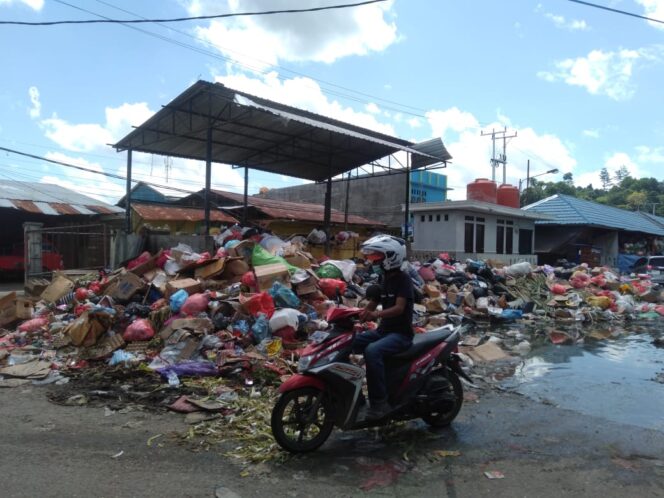 
 Kondisi sampah yang menggunung di lokasi TPS Pasar Sentral Bintuni, Kamis (30/6/2022). Nampak, seorang pengendara sepeda motor yang berkendara disisi sampah yang berbau busuk.