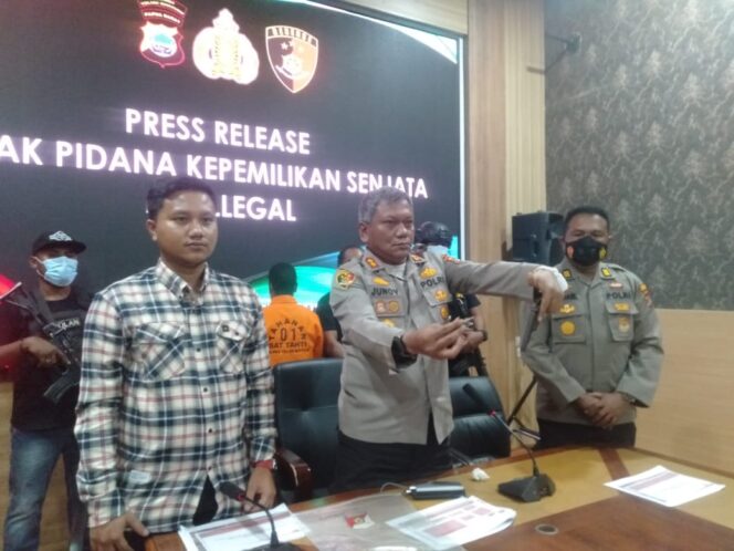 
 Kapolres saat menunjukkan barang bukti satu pucuk senpi ilegal jenis revolver rakitan dan dua butir peluru kaliber 5,56.