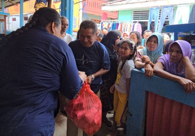 
 Ny. Kasihiw saat memberikan bantuan sembako kepada warga terdampak banjir, Selasa.