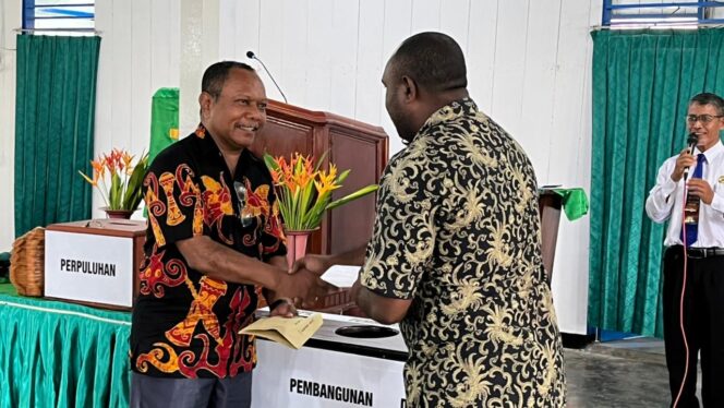 
 Ketua panitia pembangunan gedung gereja baru, Mozes M. Koropasi menerima uang hasil parkiran yang diserahkan seorang pemuda.