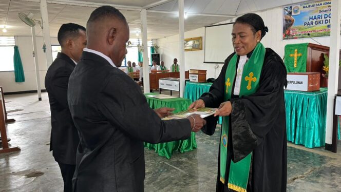 
 Anggota BP Sinode GKI di Tanah Papua Wilayah XII, Pdt. Rosalie Wamafma menyerahkan SK kepada dua Anggota BPK Lingkungan yang baru, Minggu.