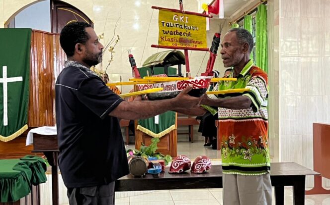 
 Replika Wai Mansusu yang diterima Eli Padwa (kiri) menandakan berakhirnya kegiatan PKB Sion Sibena di Biak, Selasa.