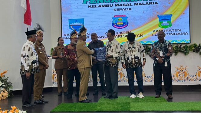 
 Gubernur Papua Barat, Dominggus Mandacan saat memberikan penghargaan kepada kabupaten yang berprestasi di bidang kesehatan.