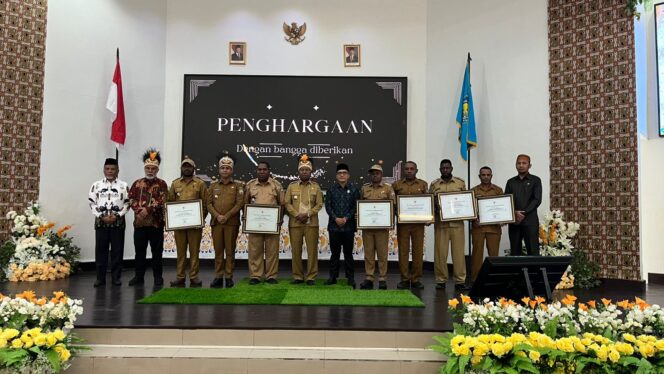 
 Gubernur Papua Barat, Dominggus Mandacan dan Bupati Teluk Bintuni, Yohanis Manibuy berpose bersama enam kepala distrik peraih penghargaan atas eliminasi malaria. 