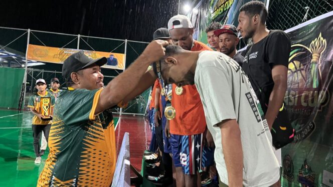 
 Ketua Harian Pengprov Perbasi Papua Barat, Rino Rumbrawer saat mengalungkan medali kepada pemain.